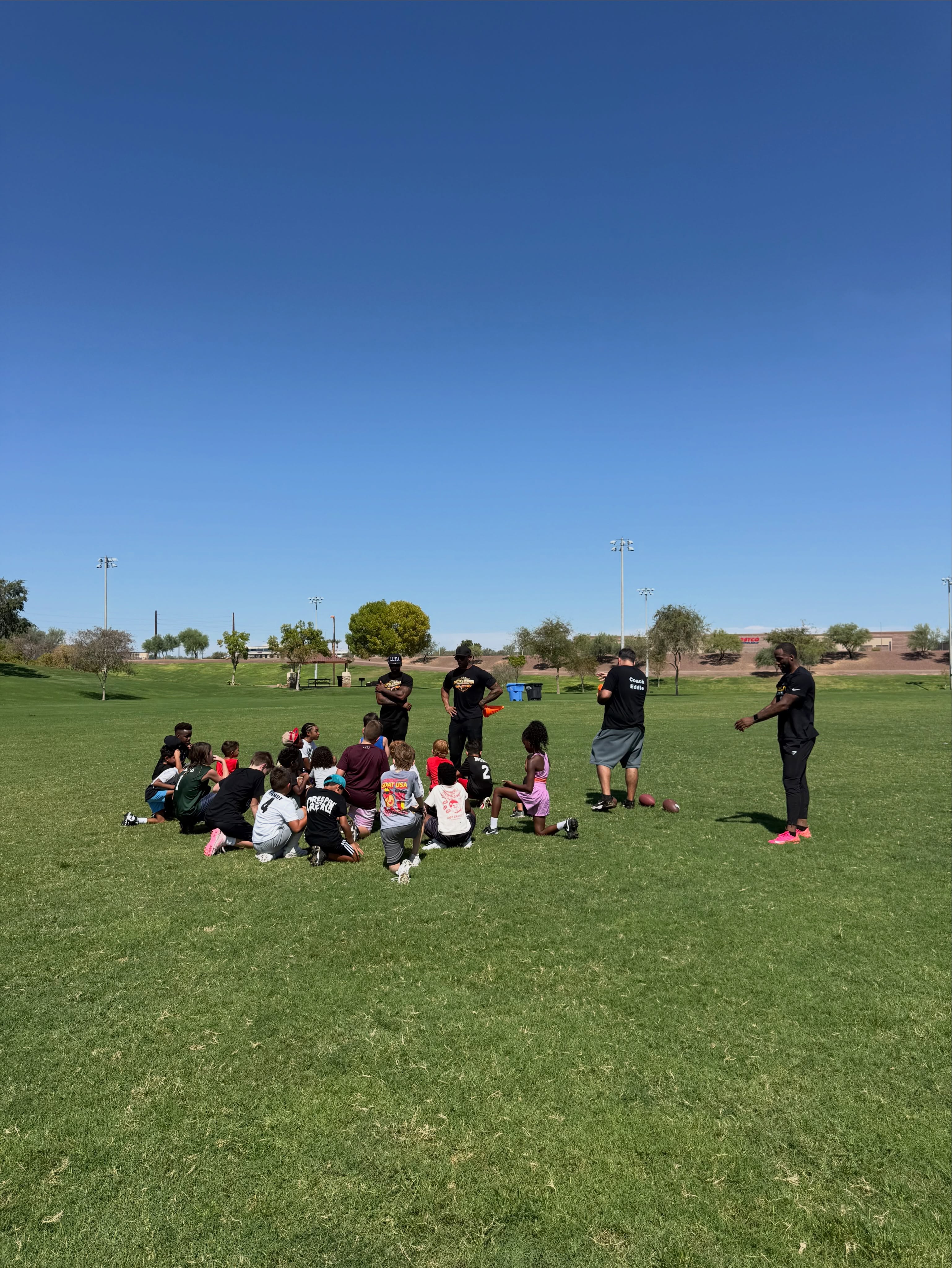 Little Legends athletes gather for group coaching on the field.